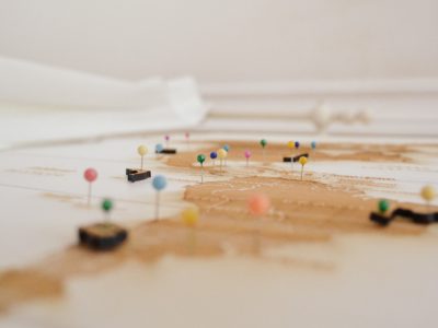 Flat view of a map with colored pushpins in it.